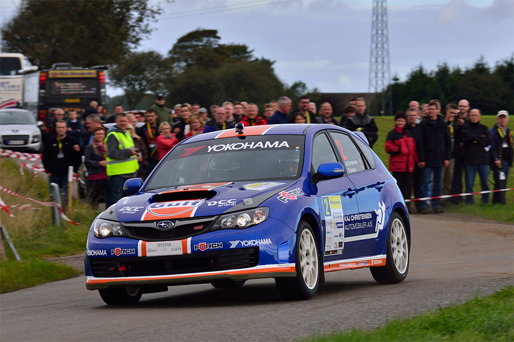 Flere hundrede tilskuere fulgte Mekonomen Rally fra start til mål og kan her nyde Max Christensen og Preben Jensen i perfekt kontrol for fuld fart gennem et hurtigt venstresving
(Foto: Michael Eisenberg, Intercom)
